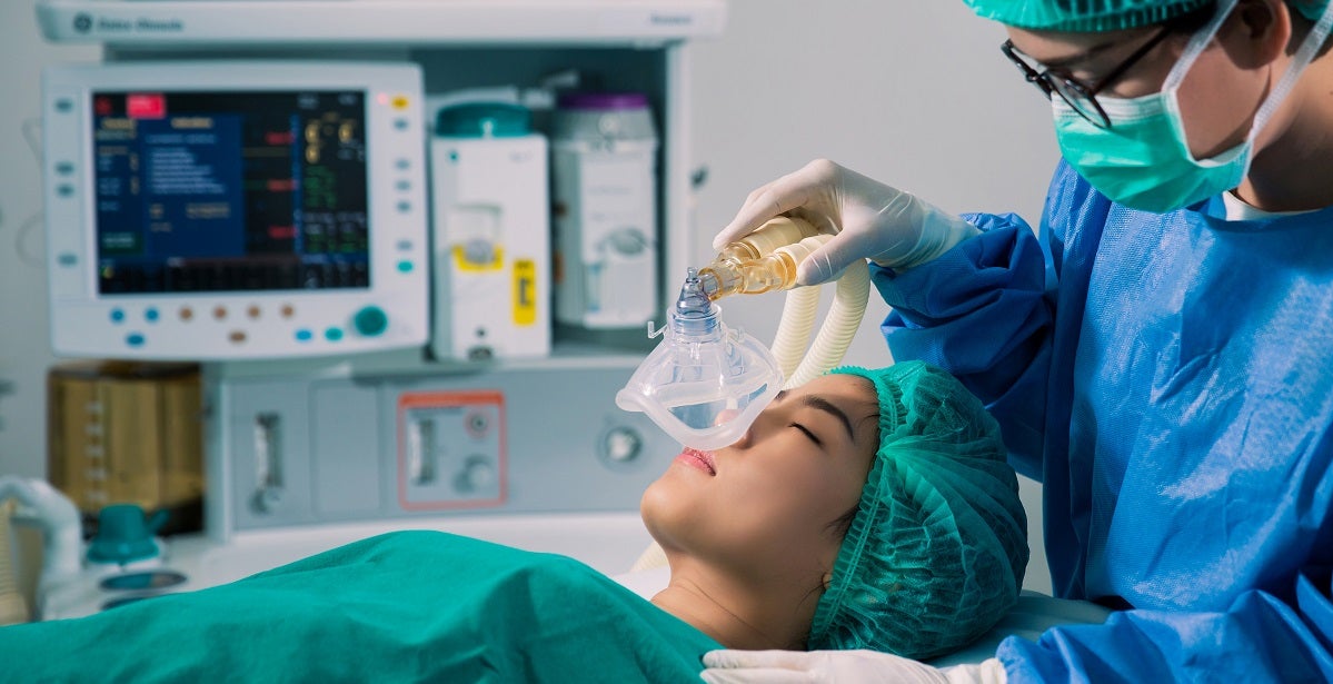 nurse anesthetists administering anesthesia to a female patient