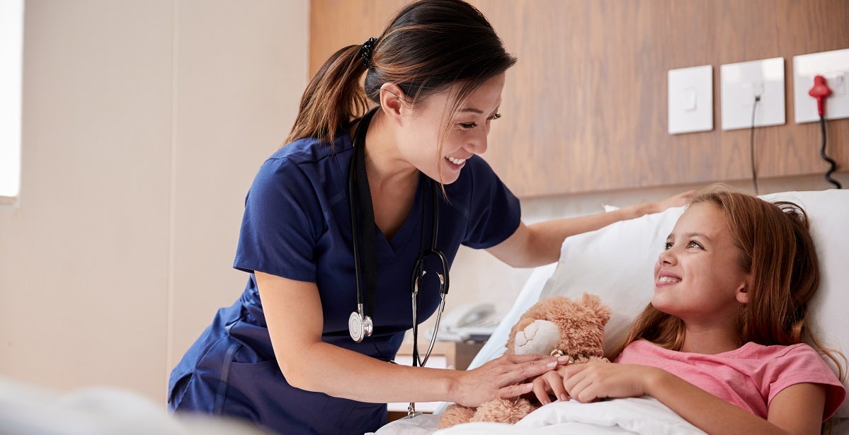 pediatric clinical nurse Visiting Girl Lying In Hospital Bed Hugging Teddy Bear